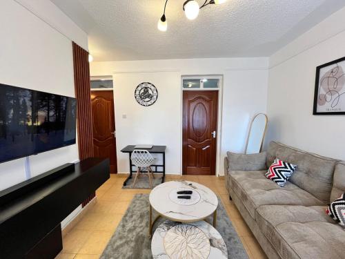 a living room with a couch and a table at Tranquil Luxury Stay, Utawala, JKIA View in Nairobi