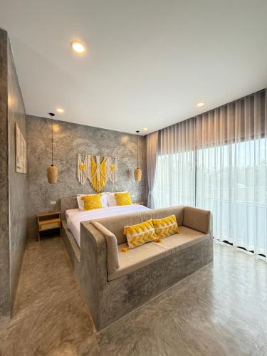 a bedroom with a large bed and a couch at The Hidden Gem in Koh Tao