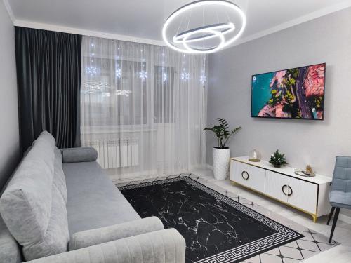 a white living room with a couch and a tv at 2-х комнатная квартира in Kokshetau