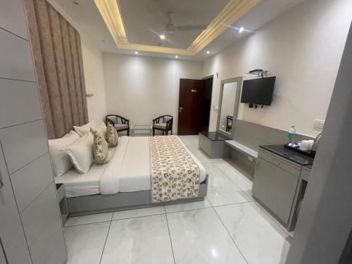 a hotel room with a bed and a television at Hotel The Saffron Park in Panchkula