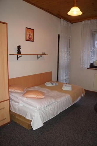 a bedroom with a bed with a shelf on the wall at Róża in Szklarska Poręba