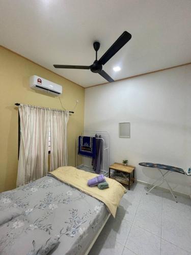 a bedroom with a bed and a ceiling fan at D'Padang KB Homestay in Kuala Berang