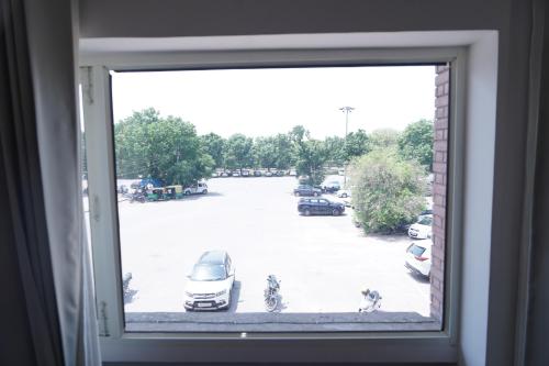 a window with a view of a parking lot at Hotel The Saffron Park in Panchkula