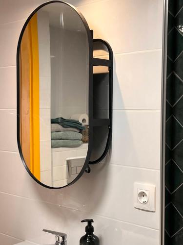a mirror on a wall above a bathroom sink at Stellar Mátra in Mátraszentimre