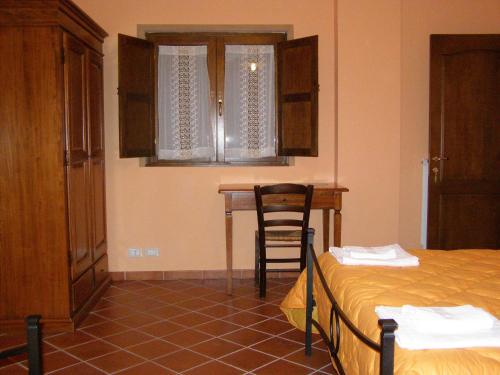 a bedroom with a bed and a table and a chair at B&B Le Grazie in Piaggine