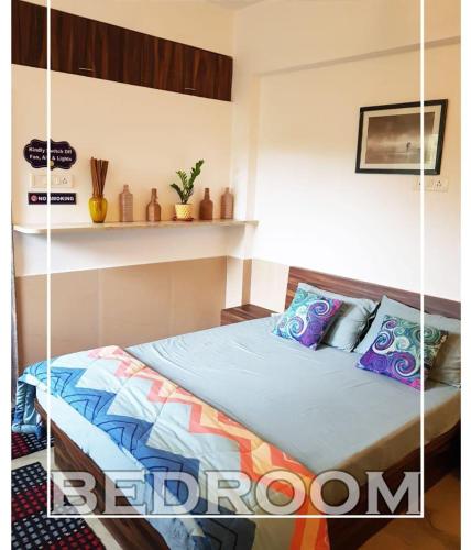 a bedroom with a bed with blue sheets and pillows at Budget casa 4BHK Villa in alibaug in Alibaug