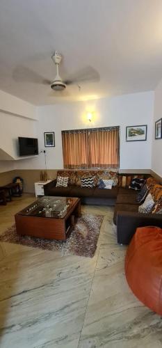 a living room with couches and a table at Budget casa 4BHK Villa in alibaug in Alibaug