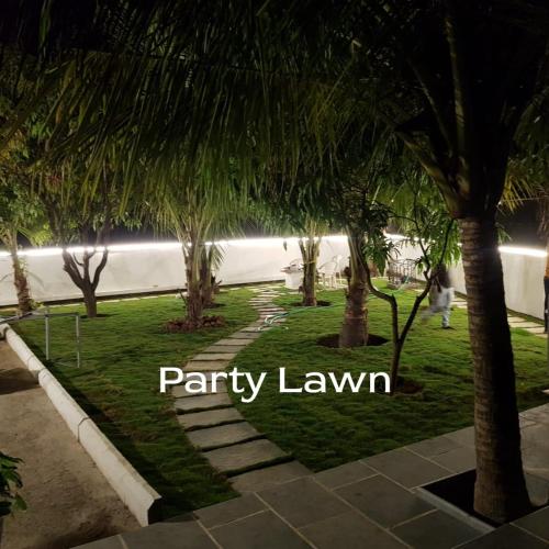 a row of palm trees in a park at night at Budget casa 4BHK Villa in alibaug in Alibaug