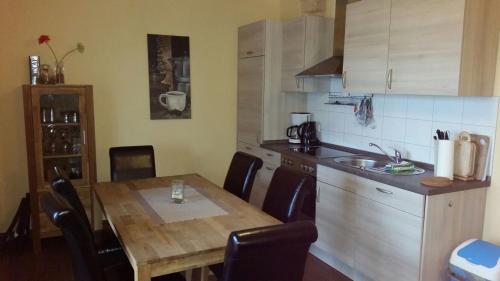 a kitchen with a wooden table with chairs and a sink at Haus Seeblick in Alt Schwerin