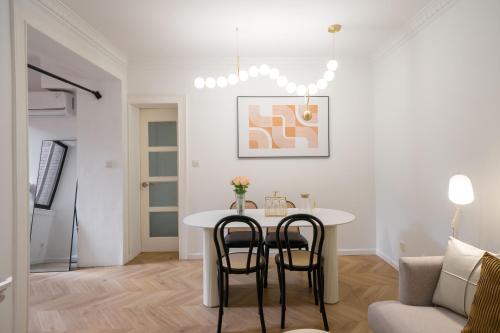 a white living room with a table and chairs at Tonight Homestay West Nanjing Road Branch Shanghai in Shanghai
