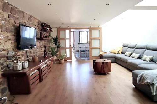 a living room with a couch and a stone wall at Vivienda Rural Perotxenea Landetxea in Doneztebe