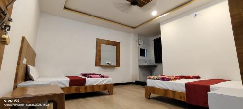 a room with two beds and a mirror on the wall at Hotel Maharana Palace in Maheshwar