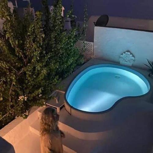 a woman standing in front of a tub in a yard at Maison Les Cyprès in Hammamet