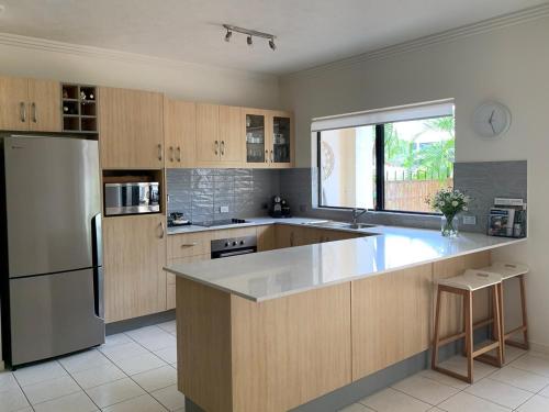a kitchen with a stainless steel refrigerator and a counter at Strand Marina-Ground Floor with Courtyard in Townsville