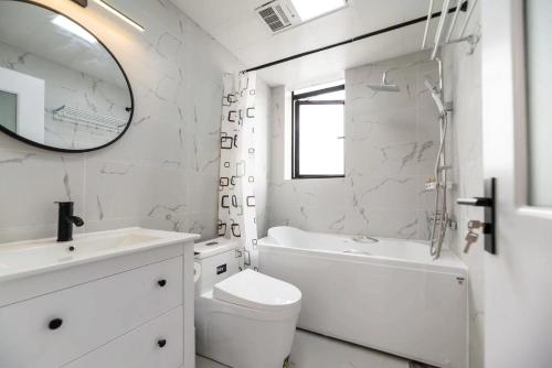 a white bathroom with a sink and a toilet and a mirror at Tonight Homestay West Nanjing Road Branch Shanghai in Shanghai