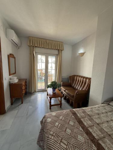 a hotel room with a bed and a couch at Hotel Mirasol in Órgiva