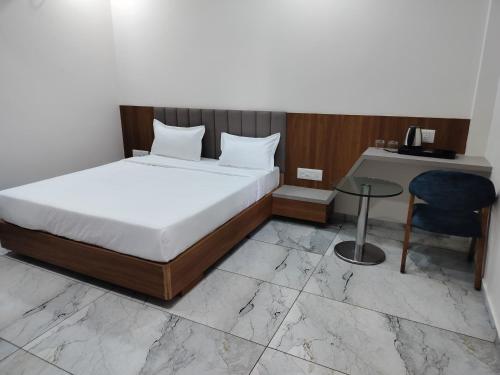a bedroom with a bed and a desk and a chair at Hotel Amrutam And Guest House in Tharād