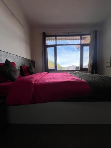 a bedroom with a large red bed with a window at Perfecto stays in Mashobra