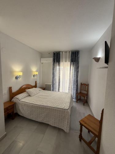a small bedroom with a bed and a window at Hotel Mirasol in Órgiva