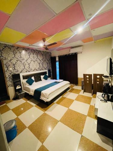 a bedroom with a bed and a checkered floor at Paradise Woodland Resort Chintpurni in Bharwain