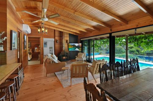 a dining room and living room with a pool at Hil & Jack's Riverfront Cabin, Merrijig Mt Buller in Merrijig