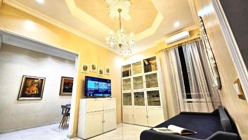 un soggiorno con divano nero e lampadario pendente di Rome Boulevard Suite a Roma