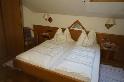a bedroom with two beds with white pillows at Gasthof Torwirt in Sankt Lambrecht