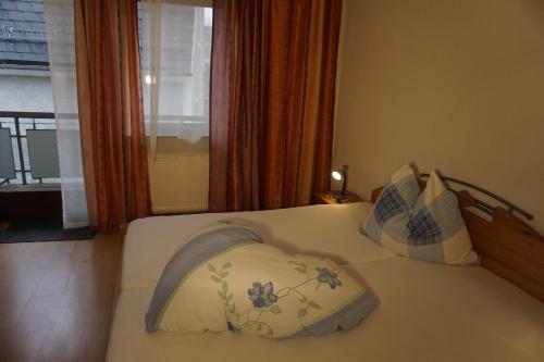 a bedroom with a bed with two pillows and a window at Gasthof Torwirt in Sankt Lambrecht