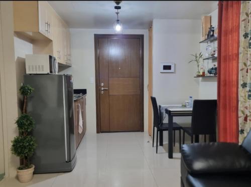 a kitchen and dining room with a refrigerator and a table at Condo Airport NAIA Terminal-3 One Palm Tree Villas in Manila