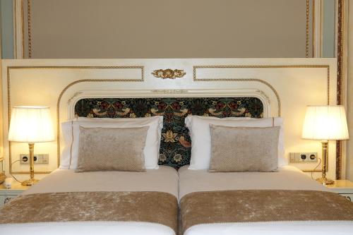 a bedroom with a large bed with two lamps at Hotel Continental Palacete in Barcelona