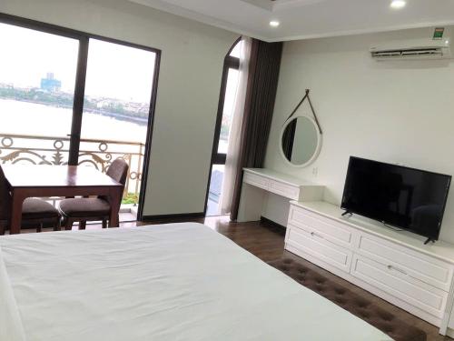 a bedroom with a bed and a flat screen tv at Queenie Hotel in Hai Phong