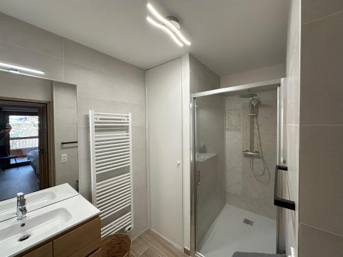 une salle de bain blanche avec une douche et un lavabo dans l'établissement Apprt moderne 70m2, 3 chbr, 6 pers, sur les pistes, tout équipé, garage intérieur, au Grand-Bornand