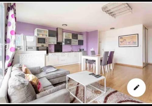 une personne assise sur un canapé dans un salon dans l'établissement Chambre proche aéroport Orly à 3 min du T12, à Viry-Châtillon