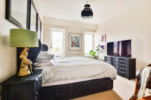 a bedroom with a large bed with a green lamp at Luxury Seaview Gated Penthouse located near Edinburgh in Kirkcaldy