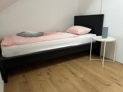 a bed with a black frame and a table with a laptop on it at House in Village apartman Jelić in Topolovac