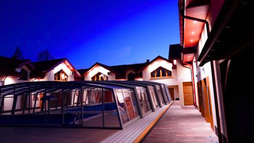 a building with a glass canopy in front of it at Apartamenty pod Dębami - noclegi Beskid Niski in Odrzechowa