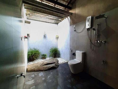 een badkamer met een toilet en potplanten. bij Dimond rick villa in Hikkaduwa