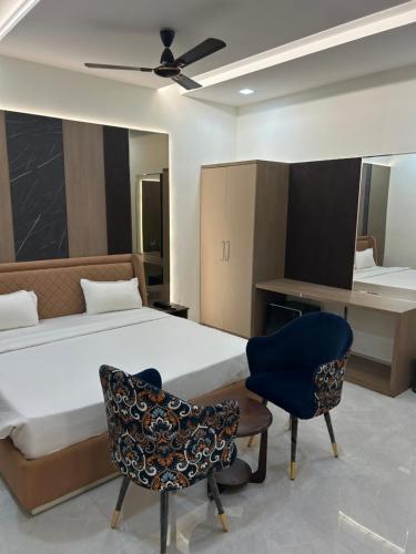 a bedroom with a bed and a desk and a chair at Kaspar Suites in Greater Noida