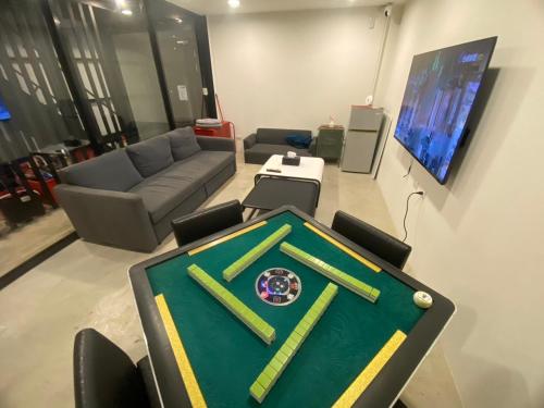 a room with a ping pong table and a couch at 藍貝島潛水背包旅宿二館 Lambay Island Dive Hostel II in Xiaoliuqiu