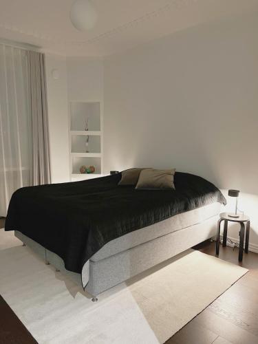 a bedroom with a large bed with a black blanket at Hidden Gem with Private Sauna, In City Center in Helsinki