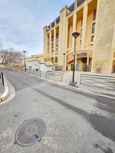 a street in front of a building with a manhole at Le Studio des Fontêtes Climatisé in Aix-en-Provence