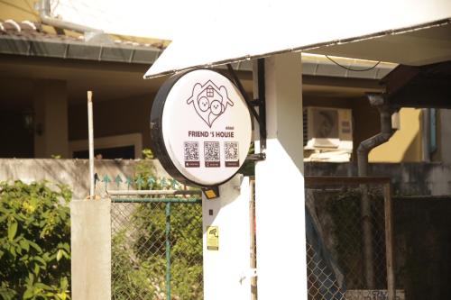 a sign in front of a house with a fence at Friend's House Arak in Chiang Mai
