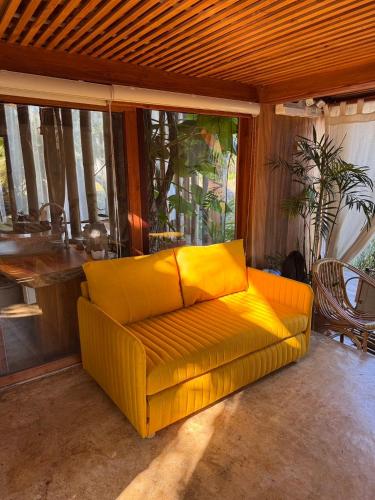 a yellow couch sitting in a living room at บ้านนาก๋างโต้ง Baan Na Kang Tong in Ban Kot