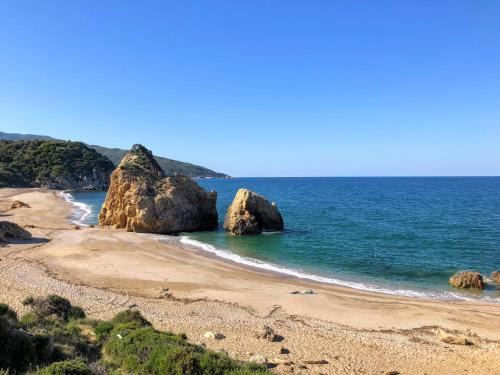 a beach with two large rocks in the ocean at Mila House in Mouresi