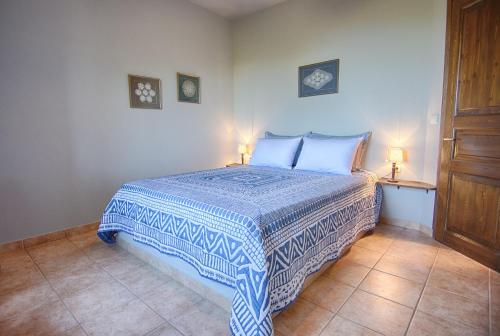 a bedroom with a blue and white bed with two lamps at Mila House in Mouresi