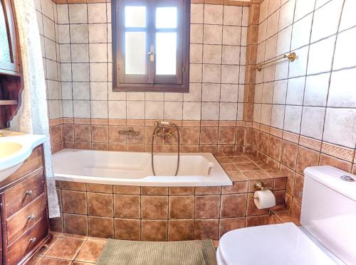 a bathroom with a tub and a toilet at Mila House in Mouresi