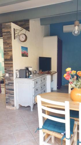 une cuisine avec une table et un bureau avec une télévision dans l'établissement studio 33 m2 au calme proche HYERES, à La Crau