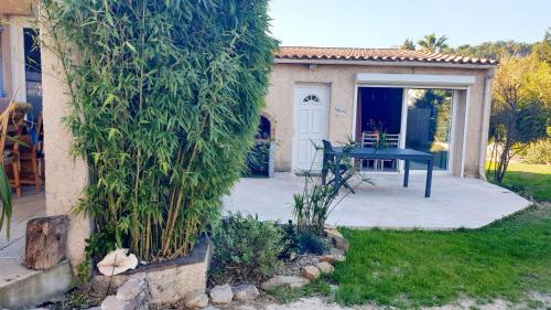 un jardin avec une table et une maison dans l'établissement studio 33 m2 au calme proche HYERES, à La Crau