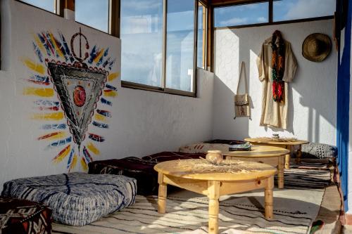 a room with two beds and a table and windows at Ossmon Surf House - Anza in Agadir