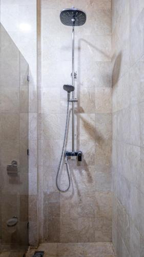 a shower with a shower head in a bathroom at Aiwan Hostel & Luggage storage in Sanur